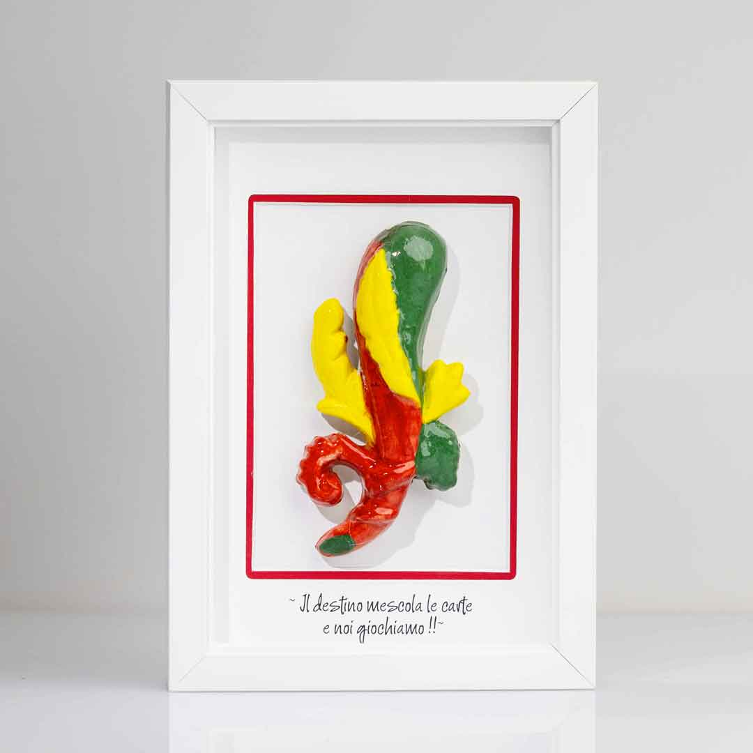 Quadro con cornice bianca contenente una riproduzione tridimensionale in ceramica dell'Asso di Bastoni delle carte napoletane. Il bastone nodoso è colorato in verde, giallo e rosso, con una forma ricurva alla base. In basso compare la scritta in corsivo: "Il destino mescola le carte e noi giochiamo!!". 