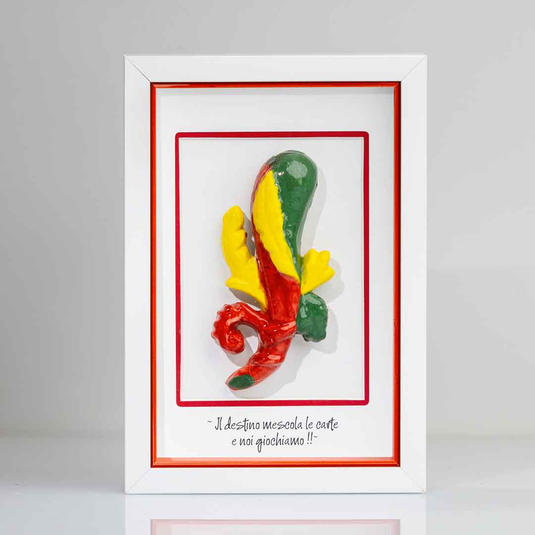 Quadro con cornice contenente una riproduzione tridimensionale in ceramica dell'Asso di Bastoni delle carte napoletane. Il bastone nodoso è colorato in verde, giallo e rosso, con una forma ricurva alla base. In basso compare la scritta in corsivo: "Il destino mescola le carte e noi giochiamo!!". Il bordo interno della cornice è rosso